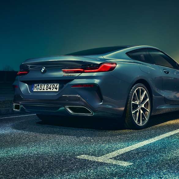 BMW 8 Series Coupé, three-quarter rear view G15. BMW 8 Series Coupé, three-quarter rear view, standing in front of night scenery G15.