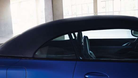소프트탑 M xDrive G83 2021이 탑재된 BMW 4 컴피티션 컨버터블 BMW M4 컴피티션 컨버터블, M xDrive G83 2021 BMW 인디비주얼 프로즌 포르티마오 블루 메탈릭, 닫힌 소프트탑 및 정면에 사람