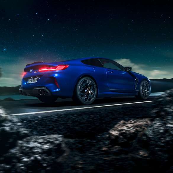 BMW M8 Competition Coupé, three-quarter side view F92. BMW M8 Competition Coupé in Marina Bay Blue metallic, driving three-quarter side view in front of starry sky F92.