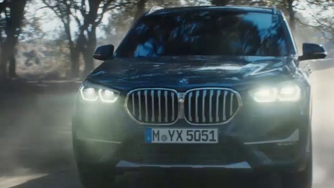 BMW X1 SUV F48, three-quarter front view. BMW X1 SUV F48, three-quarter front view driving in front nature scenery.