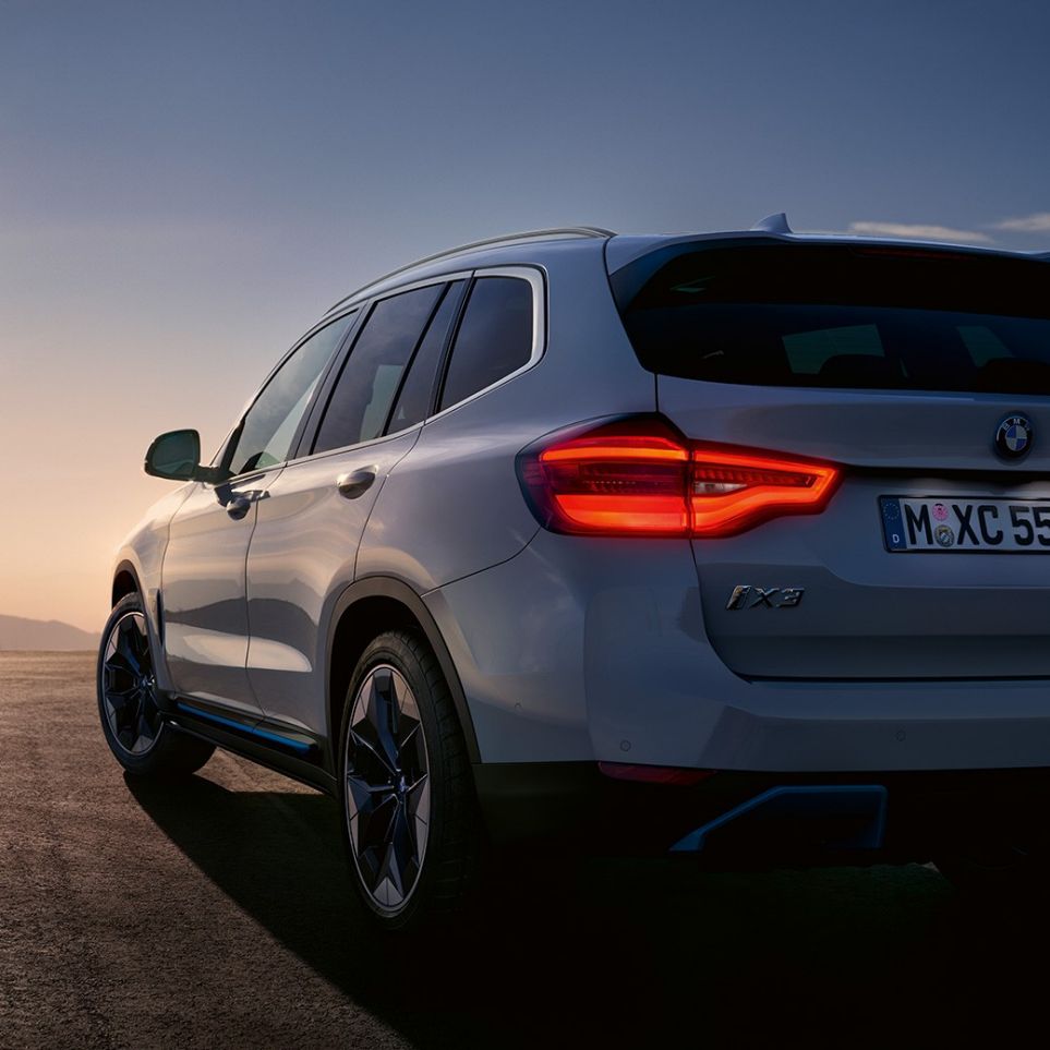 도로 주행 중인 BMW iX3 G08의 후면을 3/4각도(반측면)에서 바라본 모습 도로 주행 중인 BMW iX3 G08 2020 미네랄 화이트 메탈릭의 후면을 3/4각도(반측면)에서 바라본 모습