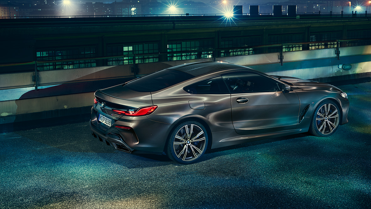 Still shot of the BMW 8 Series Coupé with BMW Individual equipment from the side in an urban setting at night. Still shot of the BMW 8 Series Coupé with BMW Individual equipment from the side in an urban setting at night.