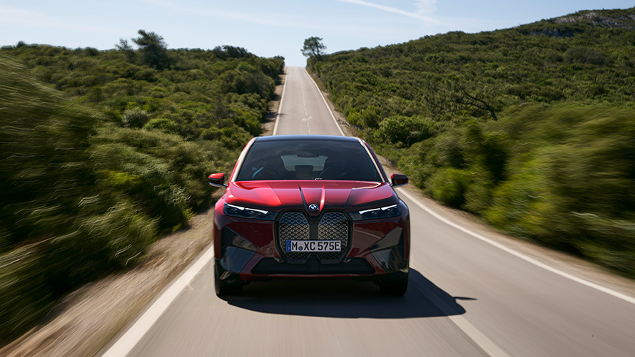 도로 위를 달리는 BMW iX i20 2021 electric SUV BMW iX xDrive50 Aventurin Red 주행 가능 거리  전기차