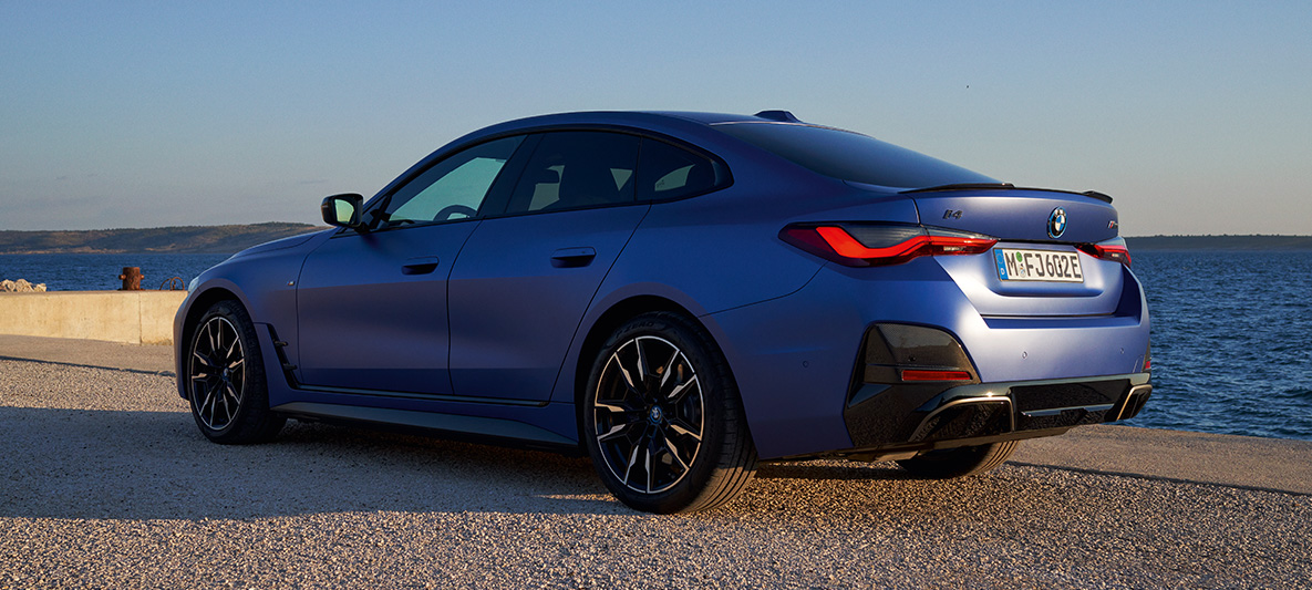 4분의 3 리어 뷰 BMW i4 M50 G26 2021 부두에서의 BMW i4 M50 G26 2021 M 포르티마오 블루 메탈릭 4분의 3 리어 뷰
