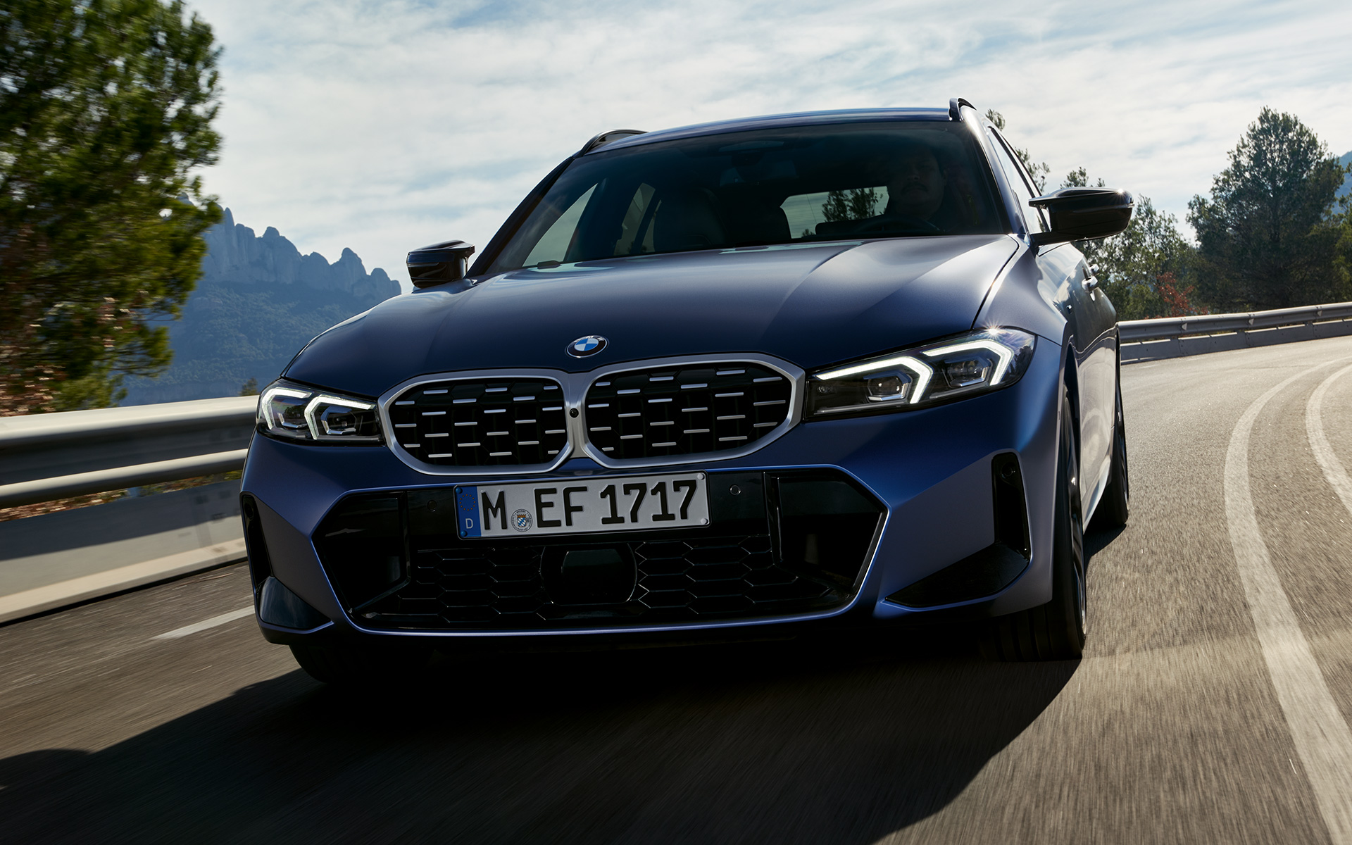 BMW M340i xDrive Touring G21 front view driving on the street BMW M340i xDrive Touring G21 Frozen Tanzanite Blue front view driving on the street