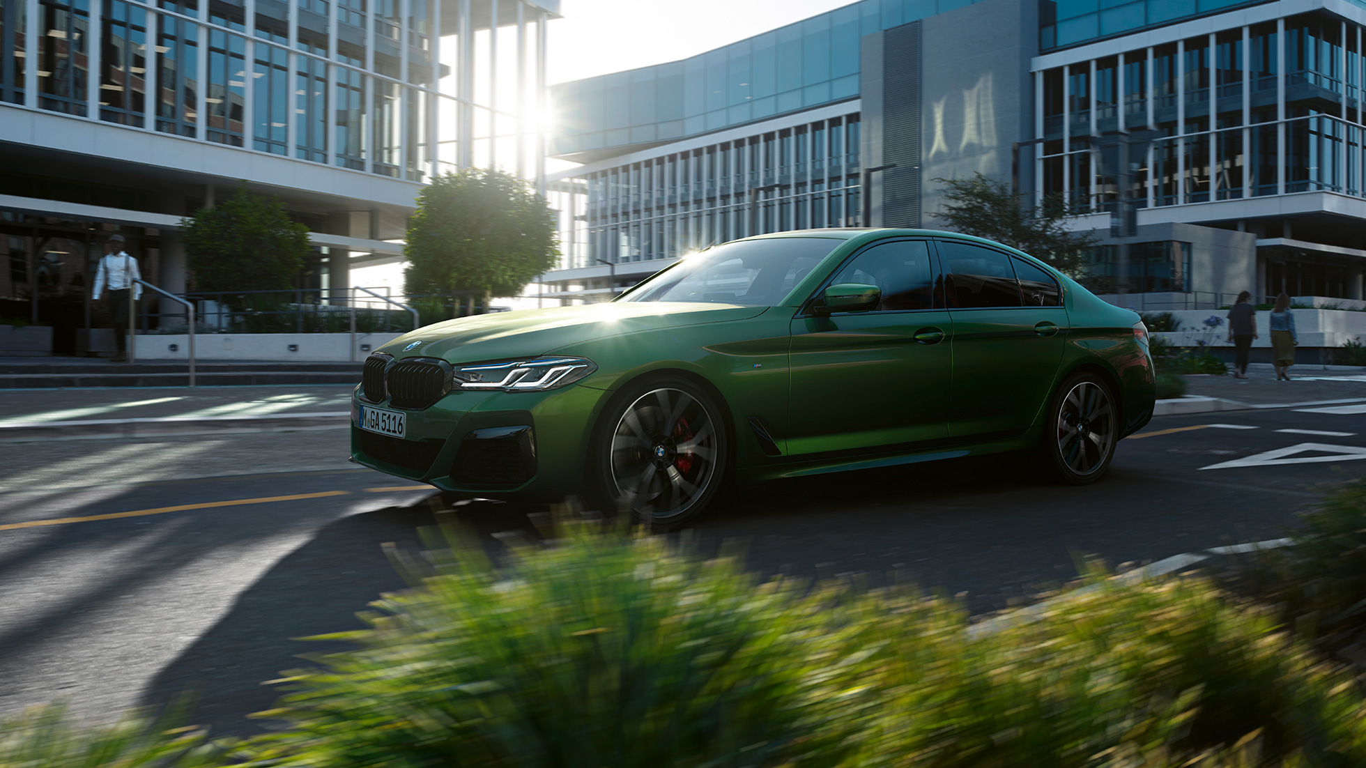 BMW M550i xDrive Sedan G30 LCI Facelift 2020 side view driving BMW M550i xDrive Sedan G30 LCI Facelift 2020 BMW Individual Verde Ermes metallic side view driving downtown