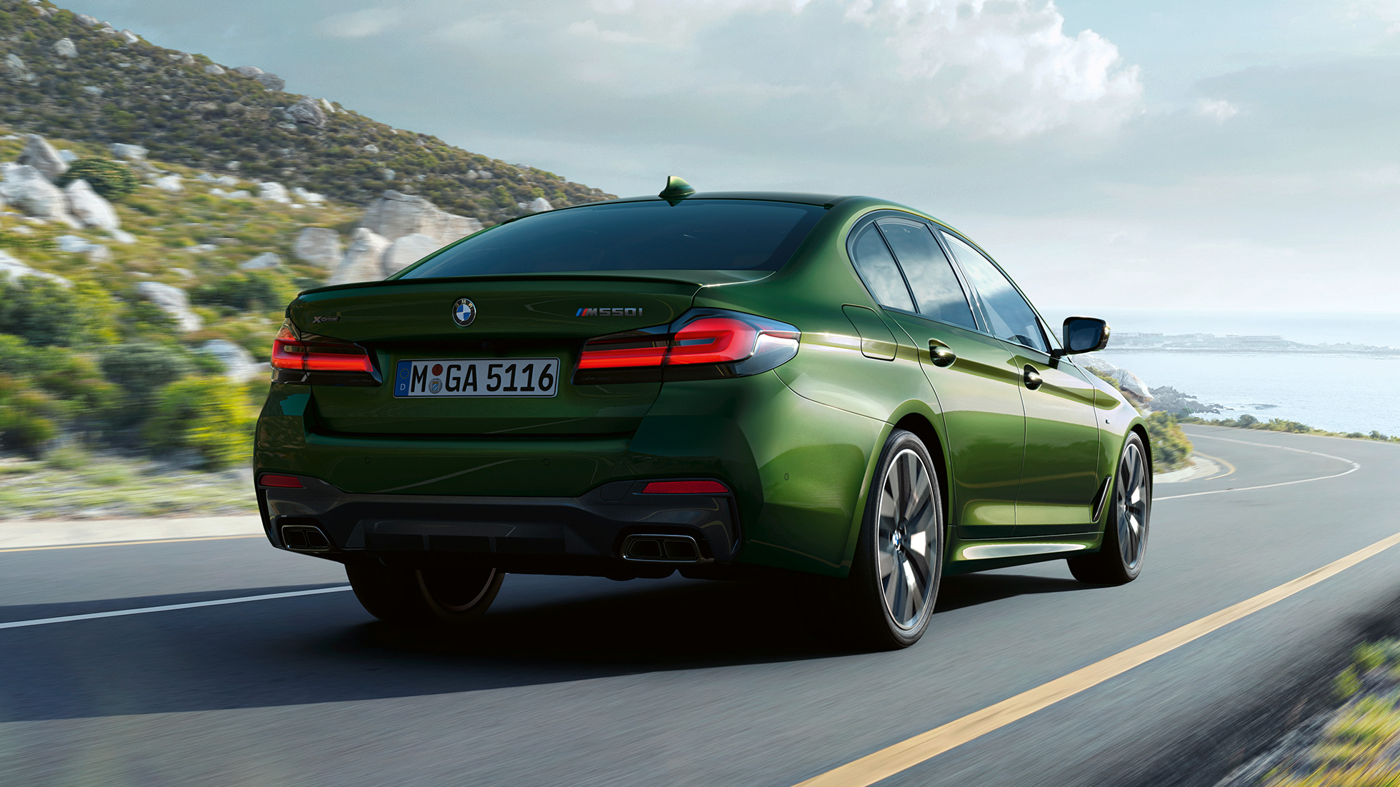 BMW M550i xDrive Sedan G30 LCI Facelift 2020 rear view BMW M550i xDrive Sedan G30 LCI Facelift 2020 BMW Individual Verde Ermes metallic rear view driving on highway