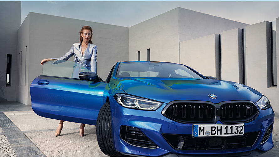 BMW M850i xDrive 쿠페 G15 LCI 페이스리프트 2022 M 포르티마오 블루 메탈릭 정면도, 열려 있는 앞문에 있는 여성 모델