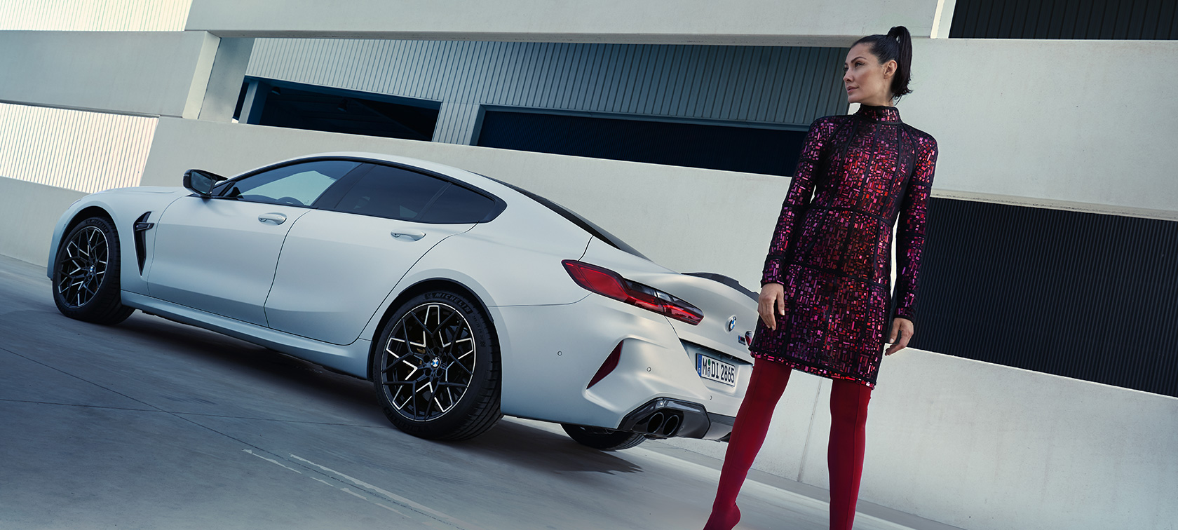 3/4 후면도 BMW M8 컴피티션 그란 쿠페 F93 LCI 2022 BMW M8 컴피티션 그란 쿠페 F93 LCI 페이스리프트 2022 BMW 인디비주얼 프로즌 브릴리언트 화이트 메탈릭 3/4 후면도, 차량 옆에 서 있는 여성 모델 포함