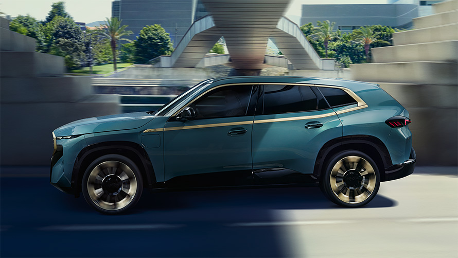BMW XM G09 외부 공간 측면도 주행 나이트 골드 액센트