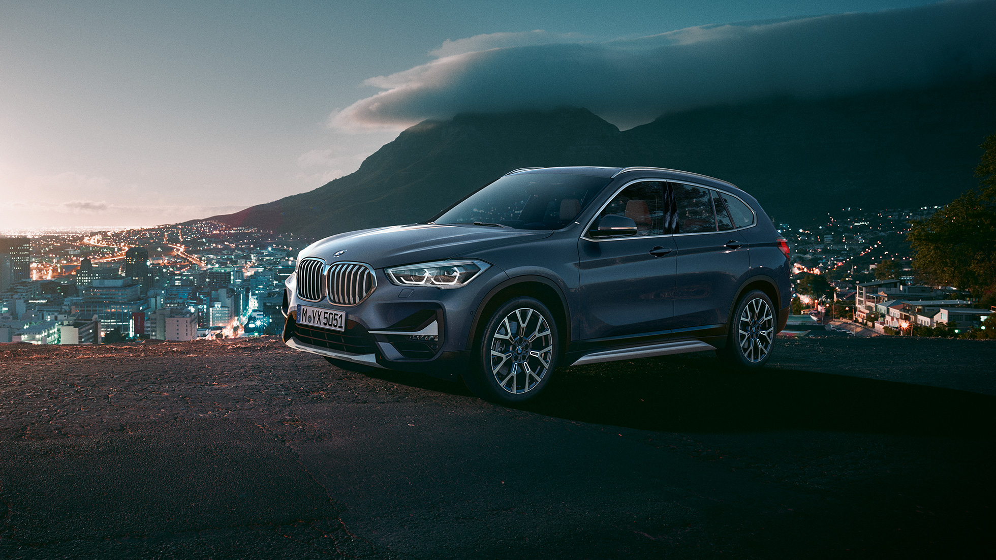 BMW X1 SUV F48, three-quarter side view. BMW X1 SUV F48, three-quarter side view standing in front of urban scenery.