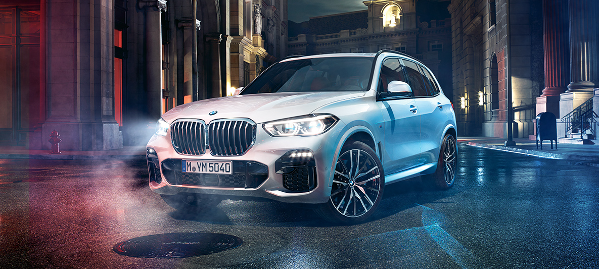 The front of the BMW X5 BMW X5 at night in an urban setting