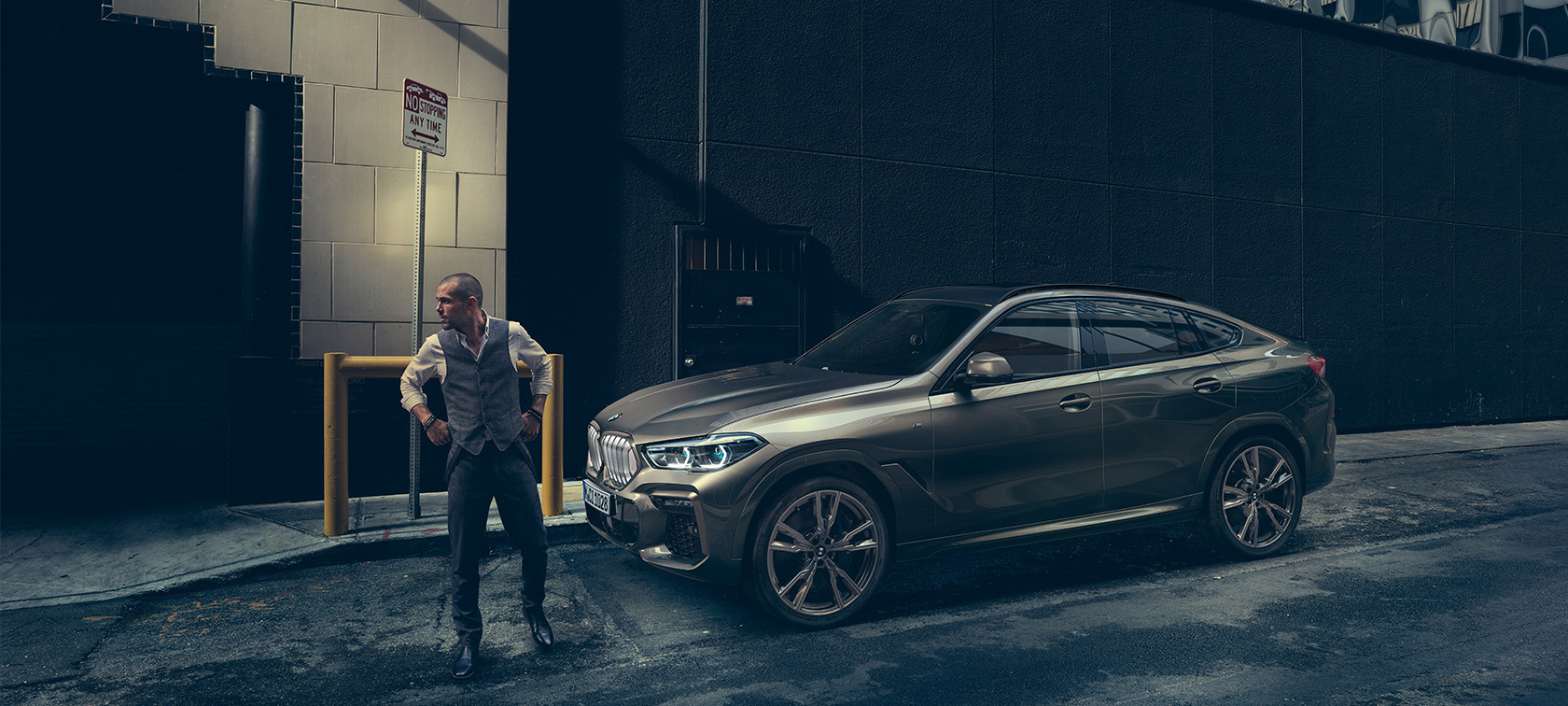 BMW X6 SUV G06. BMW X6 in lateral perspective in front of an urban setting SUV G06.