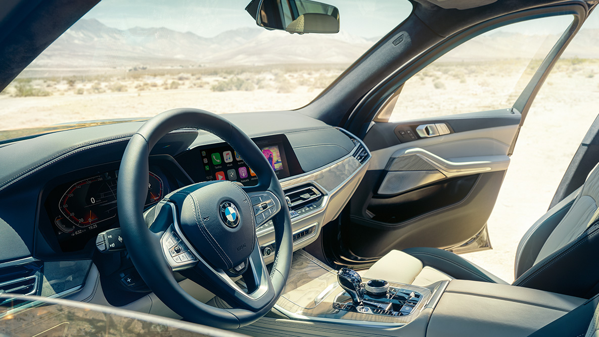 BMW X7 interior SUV G07 BMW X7 interior: view from the outside into the first row of seats with a view of the steering wheel, instrument cluster and leather seats SUV G07