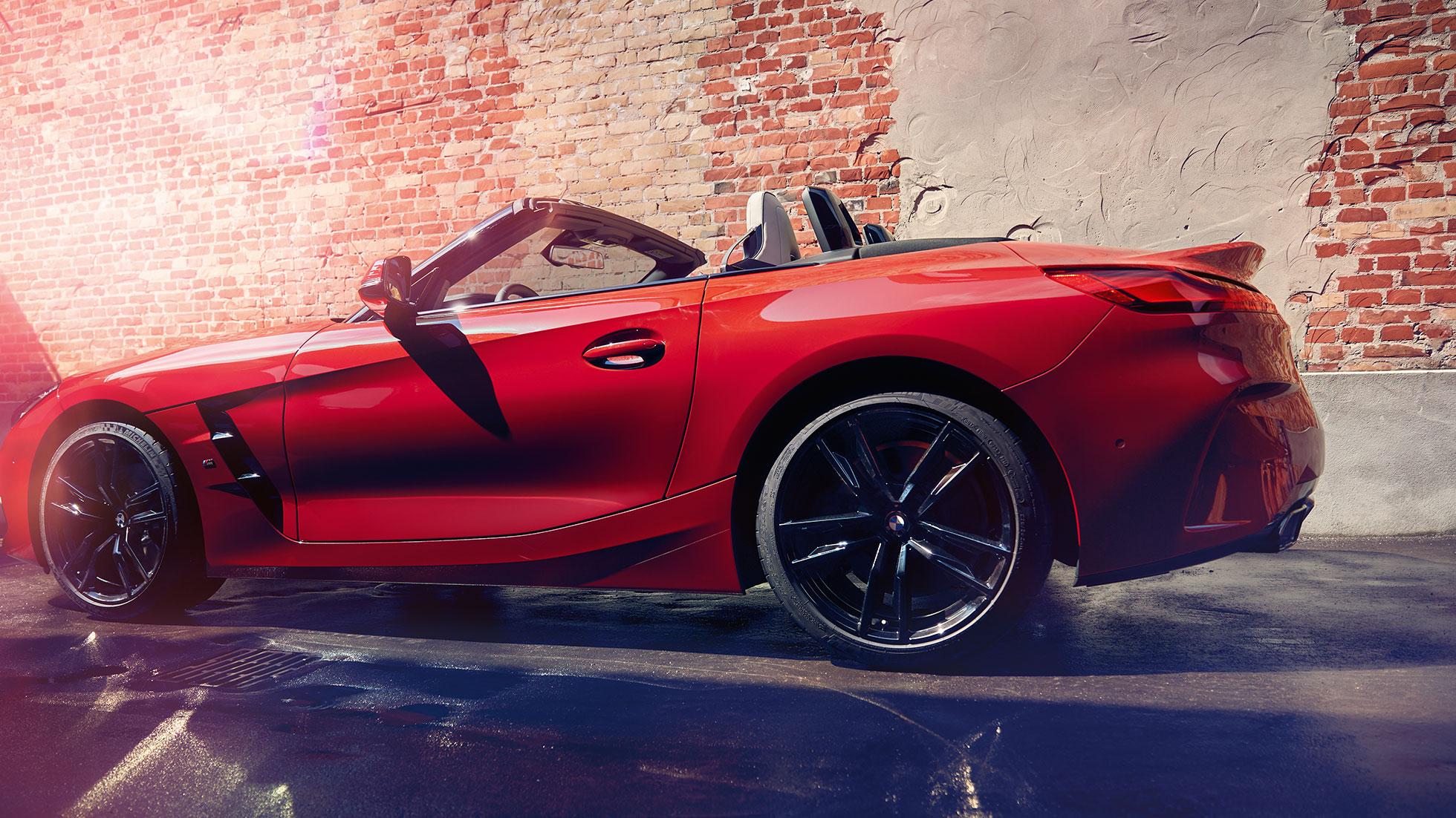 BMW Z4 로드스터 측면 벽돌 벽 앞의 BMW Z4 로드스터 측면