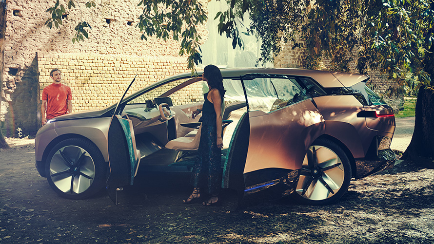 측면에서 본 BMW 비전 iNEXT BMW 비전 iNEXT의 측면과 여성, 그리고 배경 뒤 남성