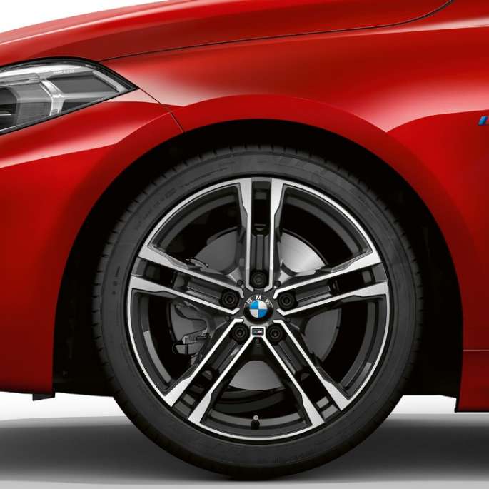 BMW 1 Series Model M Sport in Melbourne Red metallic, front from the side with 17" M light-alloy wheel Double-spoke 550 M style in Bicolour F40.